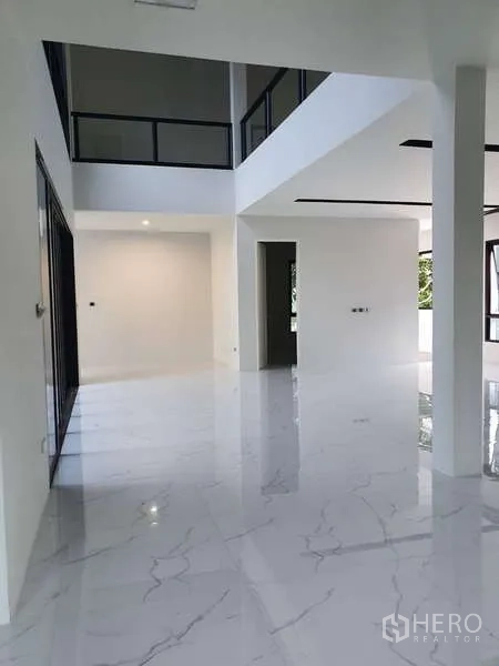 独立式住宅 出租在Phra Khanong, Bangkok - 双层挑高客厅，白色立柱与抛光大理石地面。