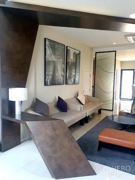 สำนักงานที่บ้าน ให้เช่าในBang Phli, Samut Prakan - มุมนั่งเล่นดีไซน์มีเอกลักษณ์ โซฟา ผนังลวดลายเรขาคณิต และประตูกระจก