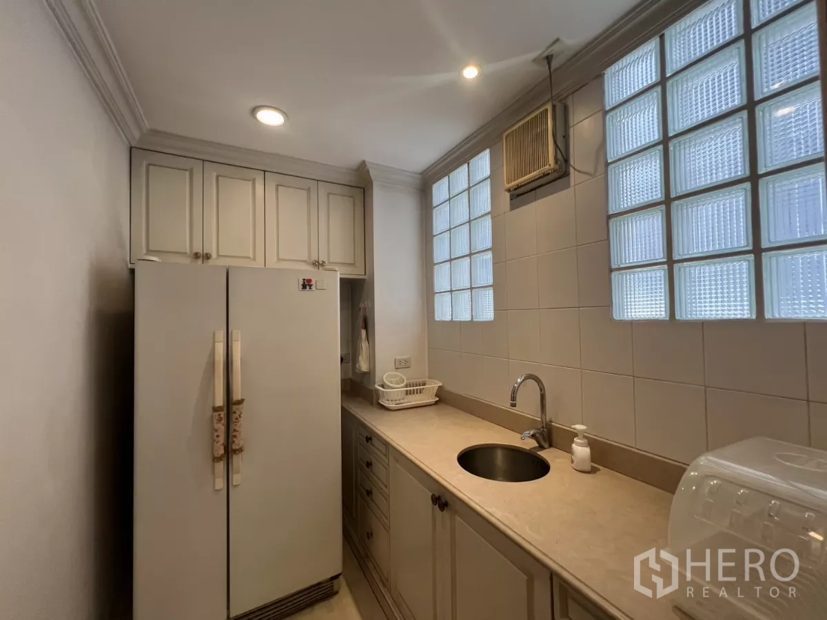 ทาวน์เฮาส์ ขายในWatthana, Bangkok - ครัวขนาดกะทัดรัด เคาน์เตอร์หิน ตู้เย็นสองประตู และหน้าต่างบล็อกแก้ว