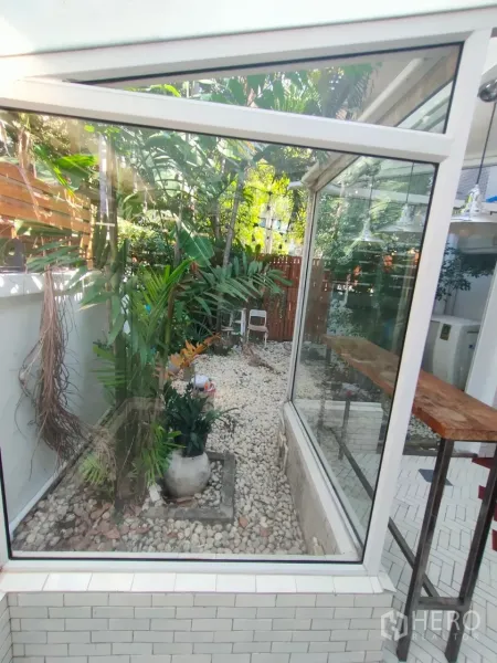零售空间 出租在Khlong Toei, Bangkok - 玻璃围合的天井花园，铺卵石与热带植物。