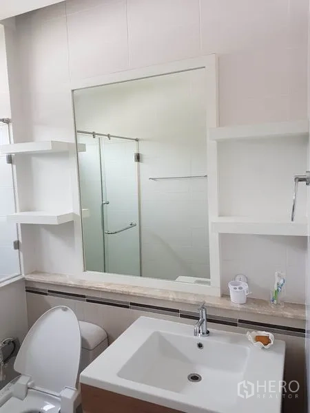 Detached House for sale in Bang Kapi, Bangkok - Modern bathroom with square basin, large mirror and glass shower enclosure.