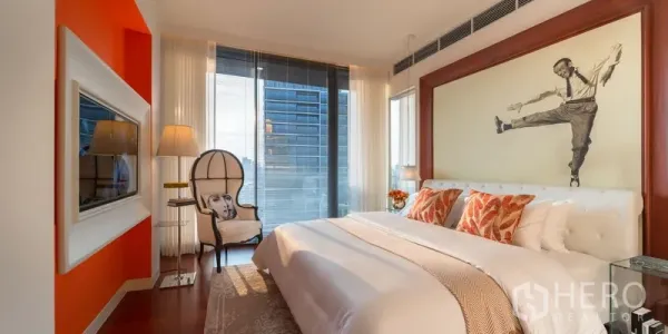 Condominium for sale in Watthana, Bangkok - Primary bedroom with large artwork, warm accents and full‑height windows with skyline views.