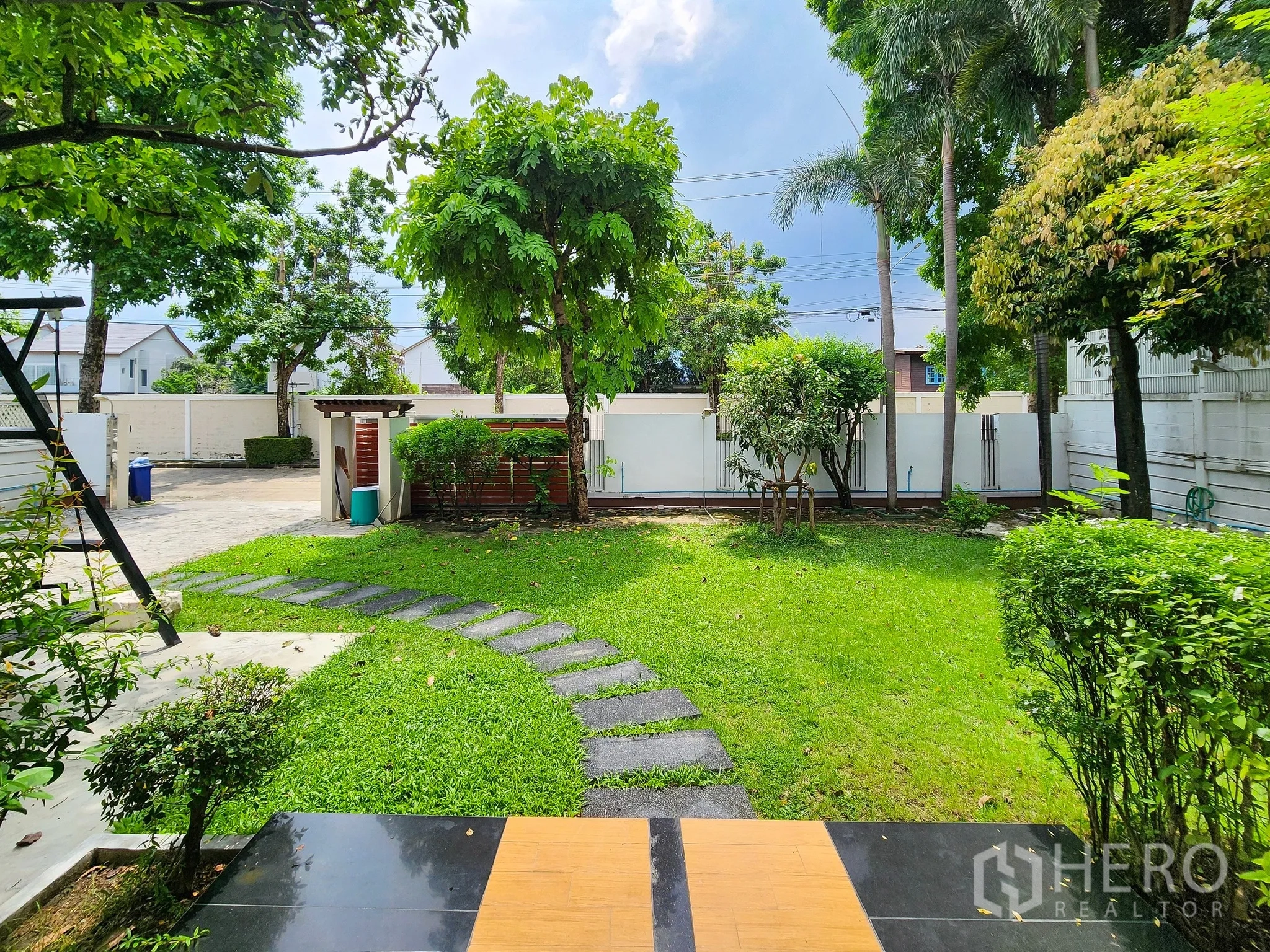 独立式住宅 出租在Bang Kapi, Bangkok - 私家庭院开阔，绿草与乔木，可见前院大门。