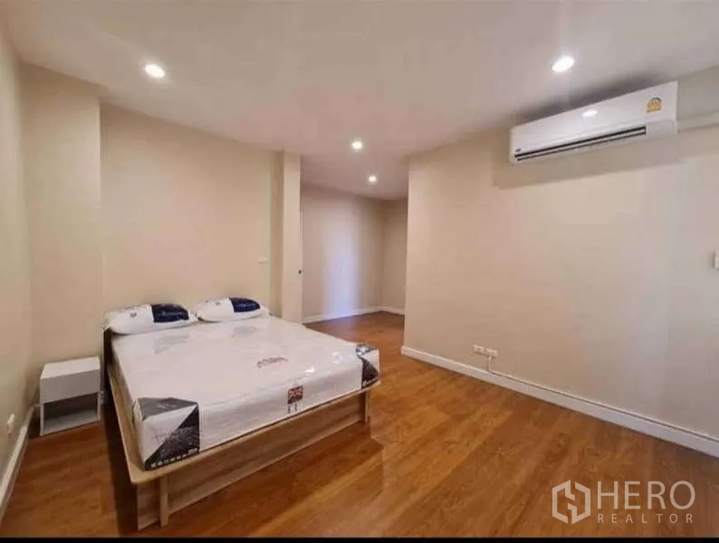 ทาวน์เฮาส์ ให้เช่าในPhra Khanong, Bangkok - ห้องนอนพื้นไม้ เตียงควีน ไฟดาวน์ไลท์ และแอร์ผนัง