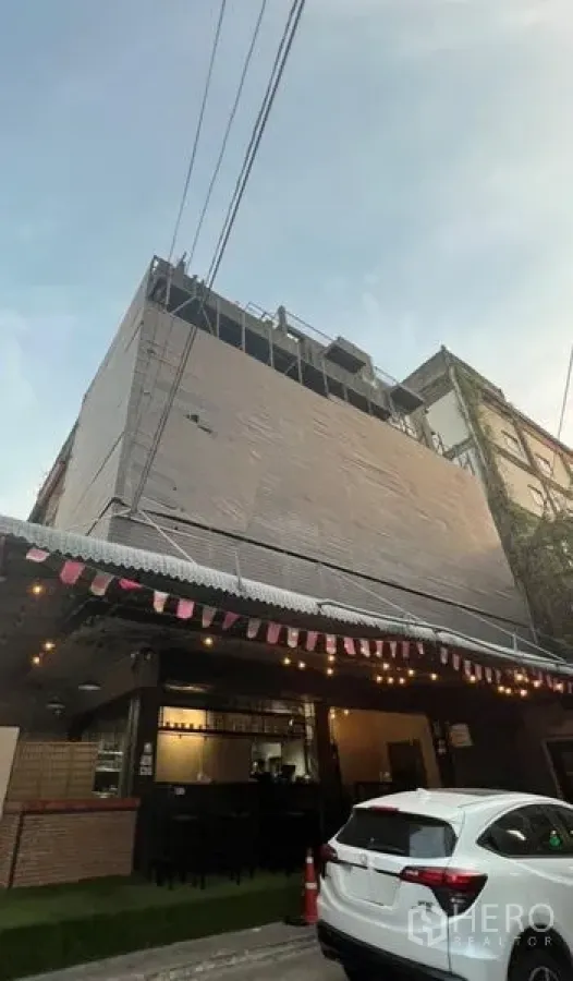 อาคารพาณิชย์ ให้เช่าหรือขายในWatthana, Bangkok - อาคารพาณิชย์หลายชั้นพร้อมชั้นล่างสไตล์คาเฟ่ หลังคากันสาดและไฟประดับบนถนนเมือง