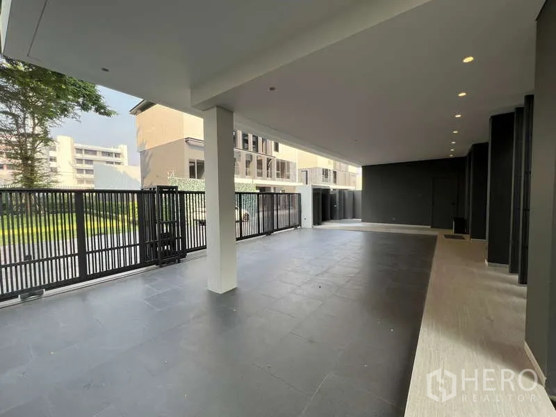 独立式住宅 出租在Suan Luang, Bangkok - 有顶车库铺石地面，黑色金属门，可停多辆车