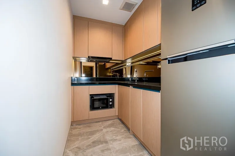 คอนโด ให้เช่าในWatthana, Bangkok - ครัวปิดรูปตัวแอล ตู้ไม้ เคาน์เตอร์หินสีดำ และเครื่องใช้ไฟฟ้า
