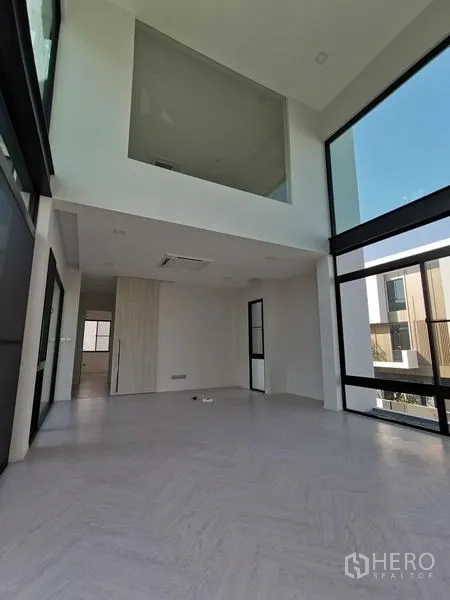 Detached House for sale in Saphan Sung, Bangkok - Expansive living area with mezzanine overlook and tall panoramic windows.