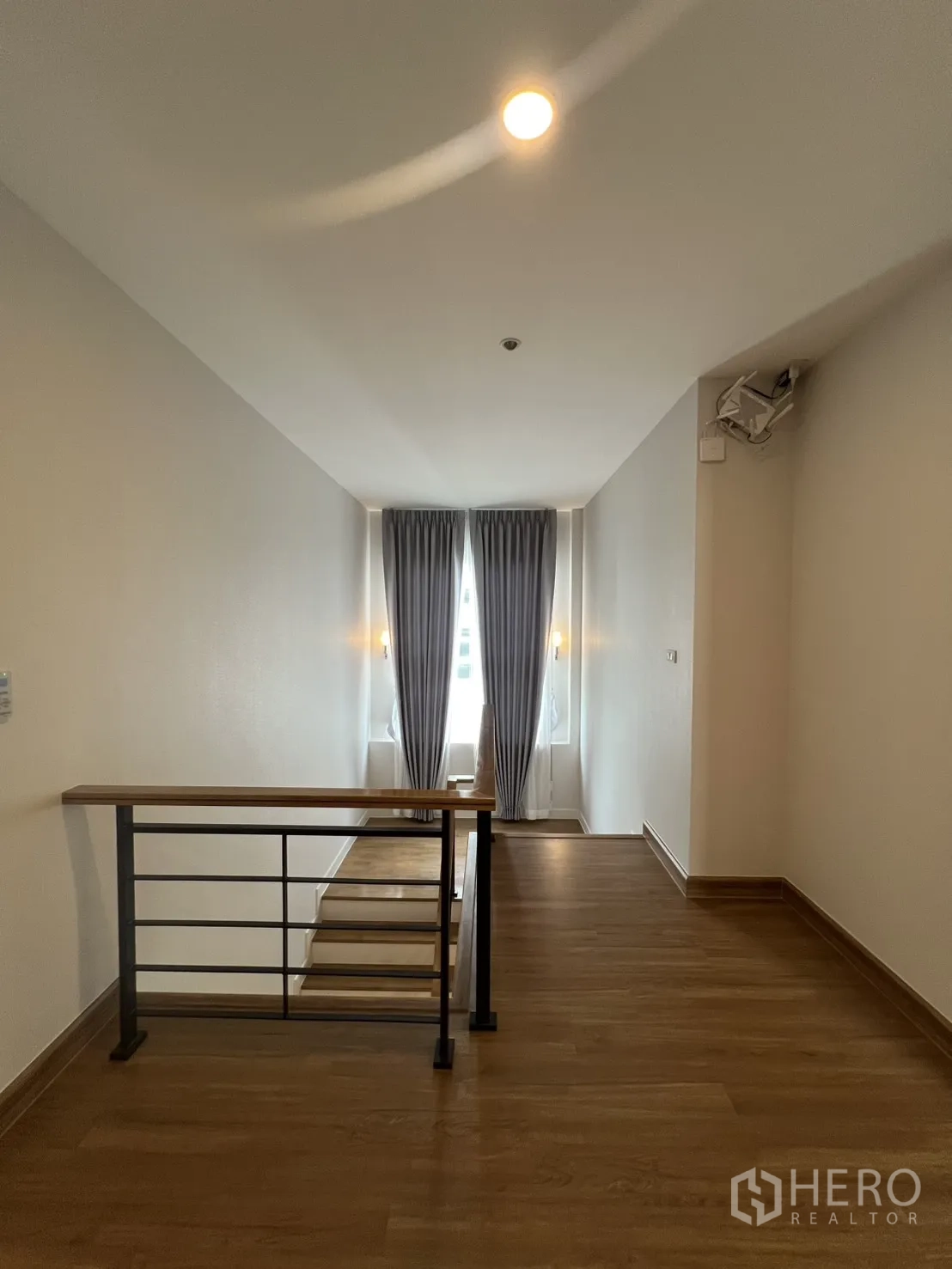 Detached House for rent in Lat Krabang, Bangkok - Stair landing with metal railing, short steps, and full-length curtains at the window.