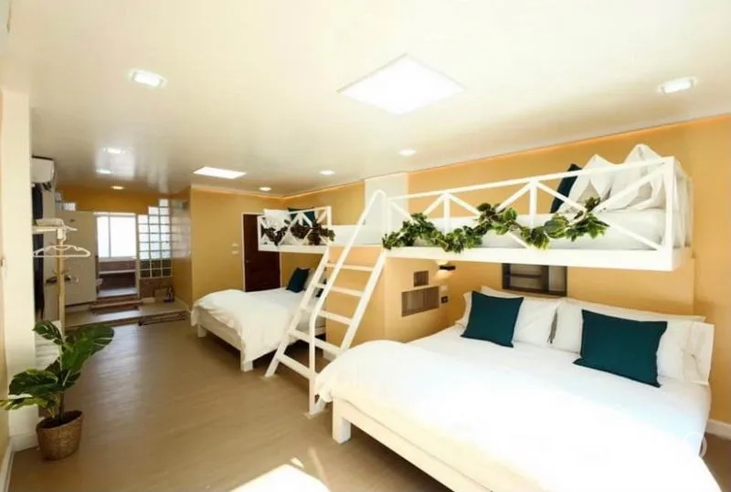 Townhouse for rent in Ratchathewi, Bangkok - Family bedroom with two beds and a lofted bunk sleeping area with ladder.