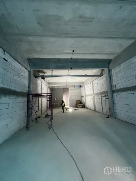 零售空间 出租在Khlong Toei, Bangkok - 开阔的店内空间，朝向后场，地面与墙面未完成。