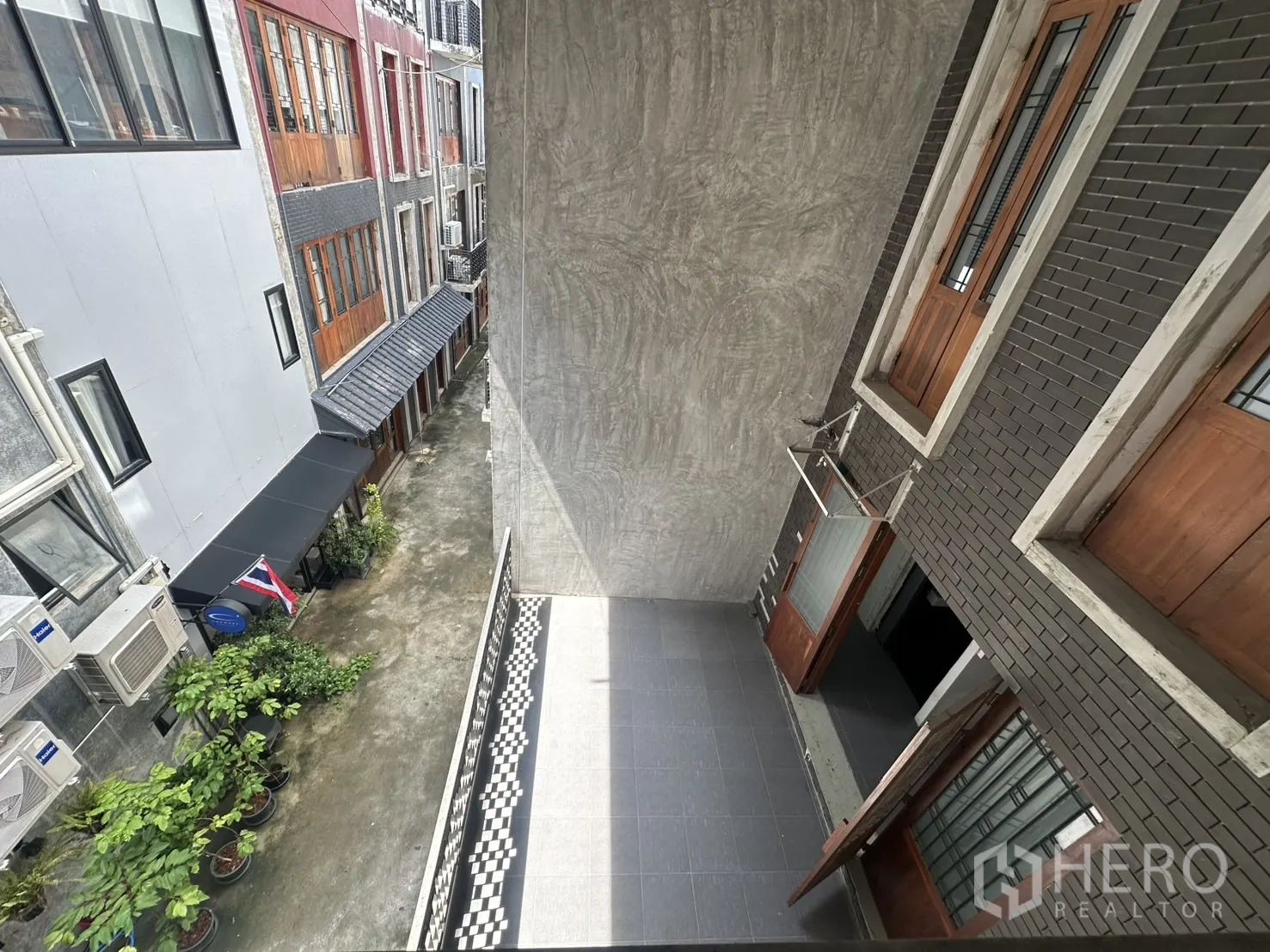สำนักงานที่บ้าน ให้เช่าในPathum Wan, Bangkok - ภาพมุมสูงมองลงตรอกแคบ มีต้นไม้ ธงชาติไทย และระเบียงอาคาร