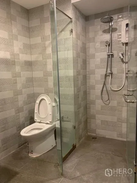 คอนโด ให้เช่า - ห้องน้ำโมเดิร์น พร้อมฉากกั้นอาบน้ำกระจก กระเบื้องลายสวย และโถสุขภัณฑ์