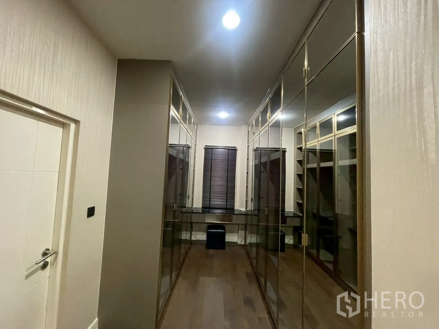 Detached House for rent in Bang Kapi, Bangkok - Corridor view of a walk-in closet with glass cabinets and dressing desk.