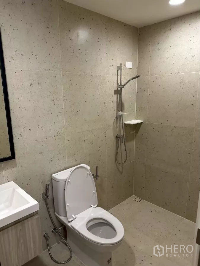 Townhouse for rent in Saphan Sung, Bangkok - Modern bathroom with walk-in shower, handheld spray and toilet.