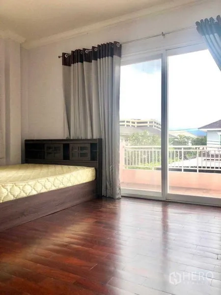 บ้าน ขายในLat Krabang, Bangkok - ห้องนอนสว่างพื้นไม้พร้อมประตูกระจกบานเลื่อนออกสู่ระเบียง