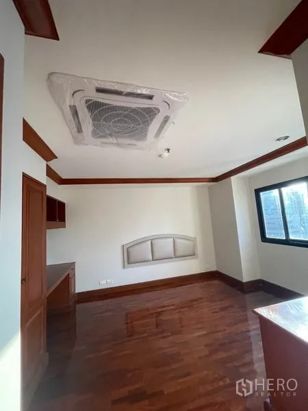 公寓 出租在Watthana, Bangkok - 采光良好房间，吊顶嵌入式空调、内置书桌与亮面木地板。