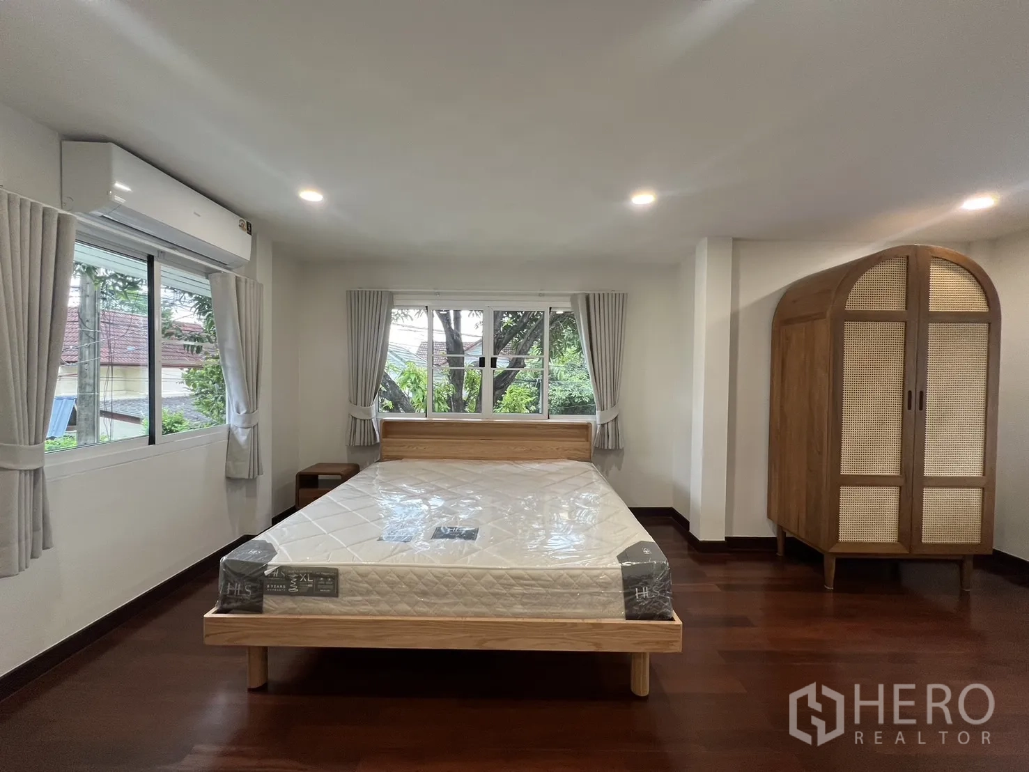 Detached House for rent in Saphan Sung, Bangkok - Large master bedroom with big windows, wooden bed and wardrobe.