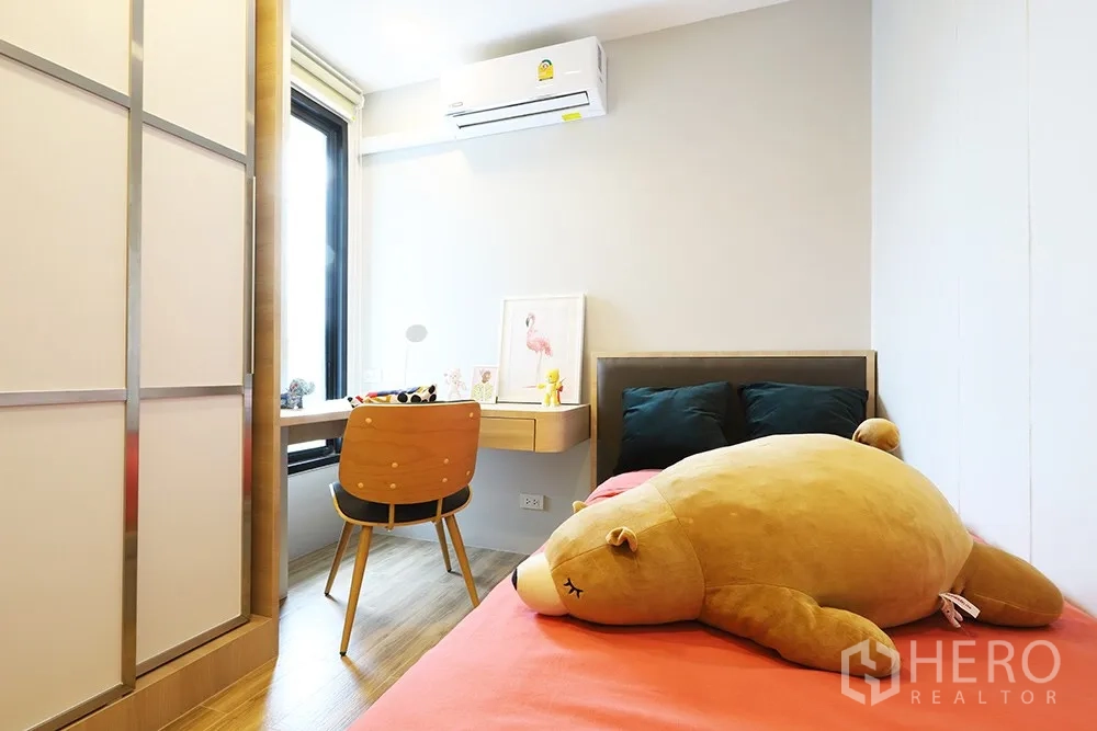 Condominium for rent in Watthana, Bangkok - Compact bedroom with a single bed, built-in desk by the window and a sliding-door wardrobe.