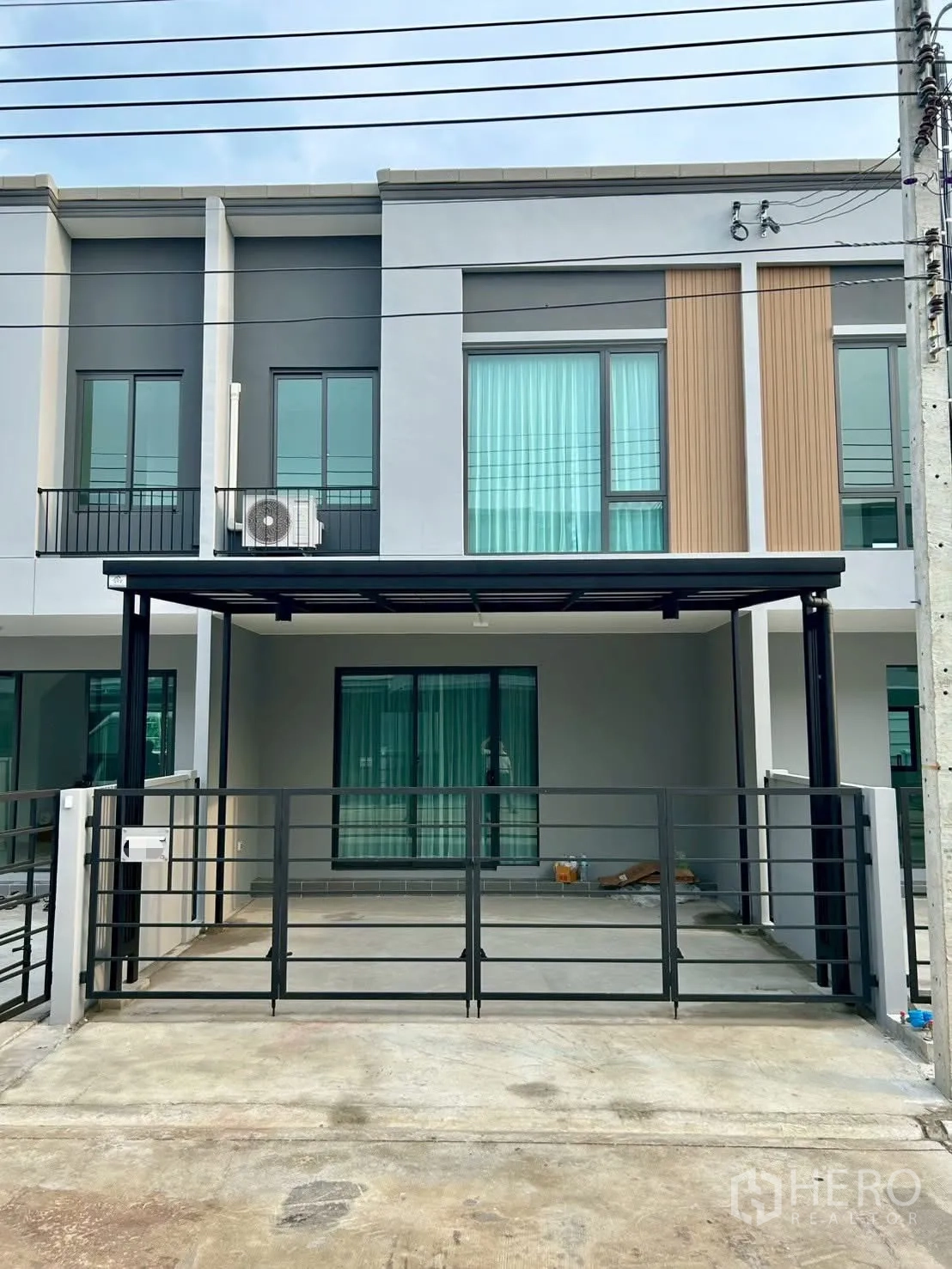 Townhouse for rent in Bang Phli, Samut Prakan - Modern townhouse facade with gated covered carport.