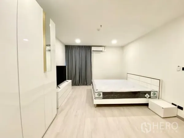 คอนโด ให้เช่า - ห้องนอนกว้างพร้อมตู้เสื้อผ้ามันวาว ชุดทีวี และม่านสีเข้ม