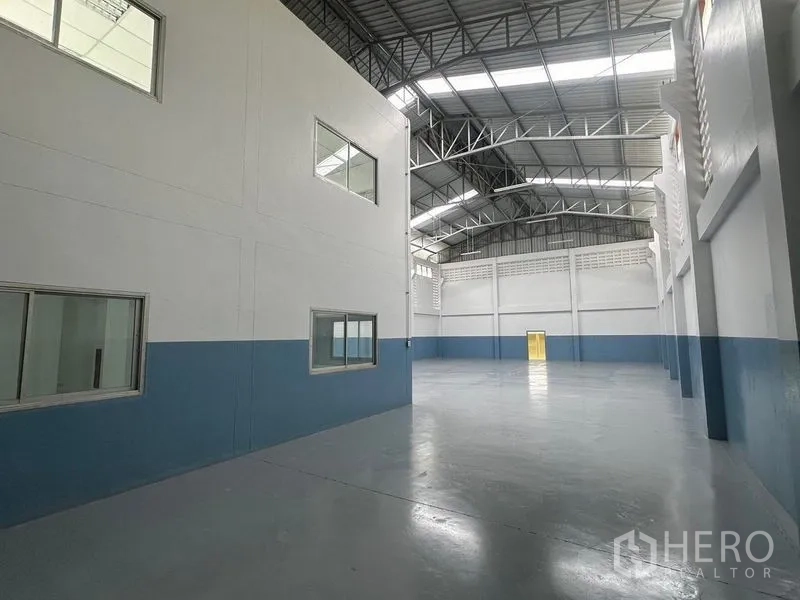 工厂 出租在Pathum Thani - 宽敞仓库大厅，高钢桁架屋顶与天窗采光。