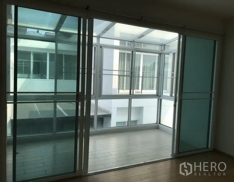 Detached House for sale in Suan Luang, Bangkok - Enclosed glass balcony or sunroom with sliding doors and windows.