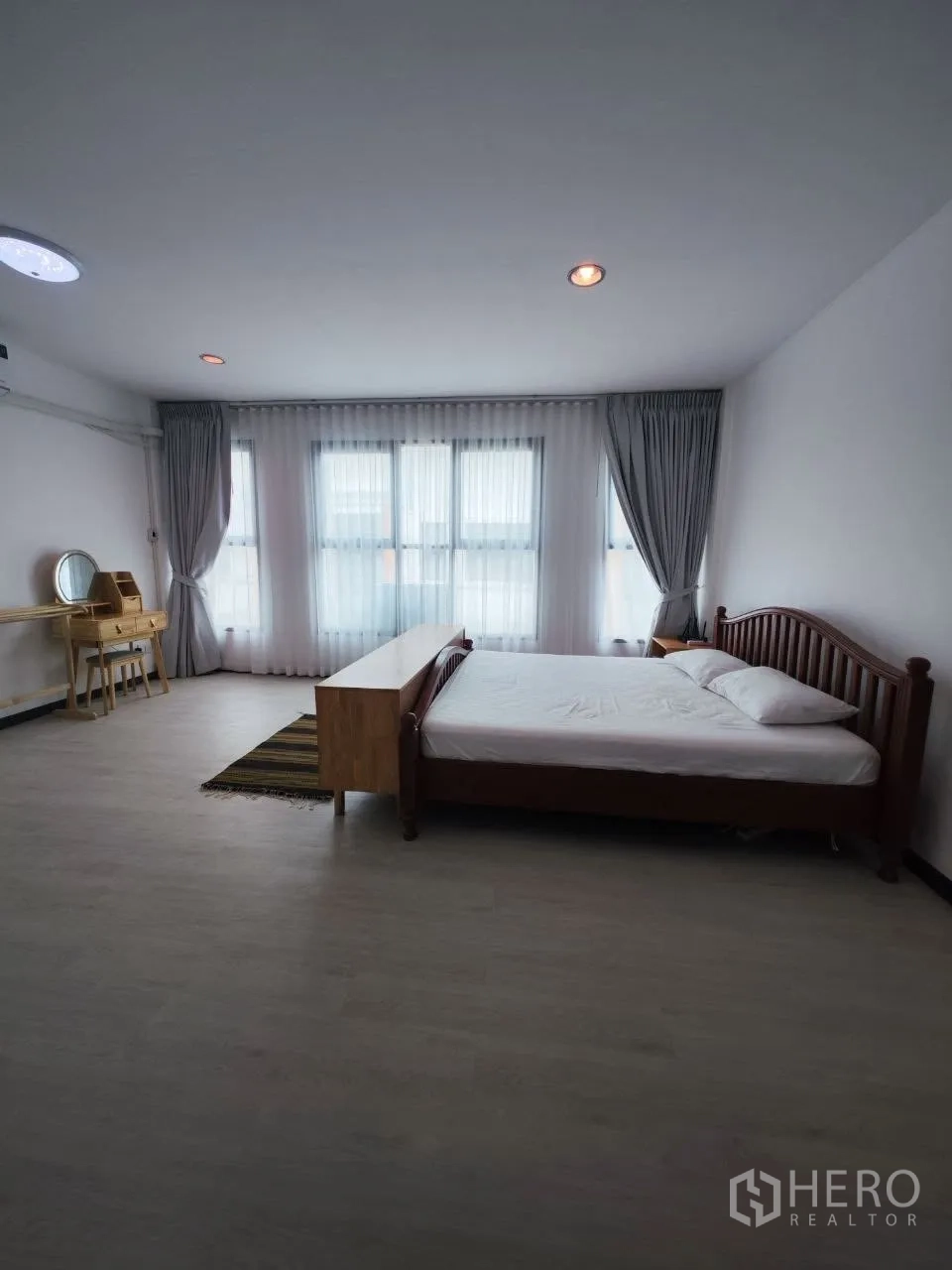家庭办公室 for rent in Bang Na, Bangkok - 大卧室配床、书桌与带窗帘的落地窗。