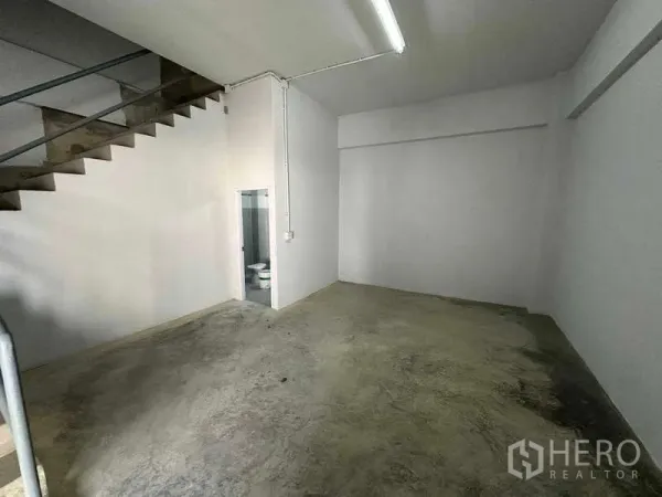 คลังสินค้า ให้เช่าในSamut Sakhon - พื้นที่ชั้นล่างพื้นปูน มีบันไดขึ้นชั้นบนและประตูเข้าห้องน้ำ