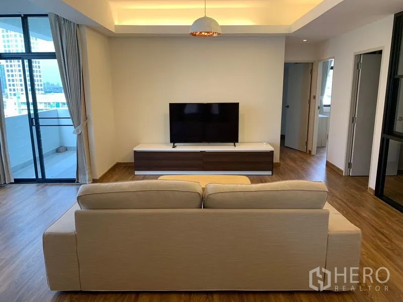 คอนโด ให้เช่า - ห้องนั่งเล่นกว้าง โซฟา ตู้วางทีวี และประตูกระจกบานเลื่อนออกระเบียง