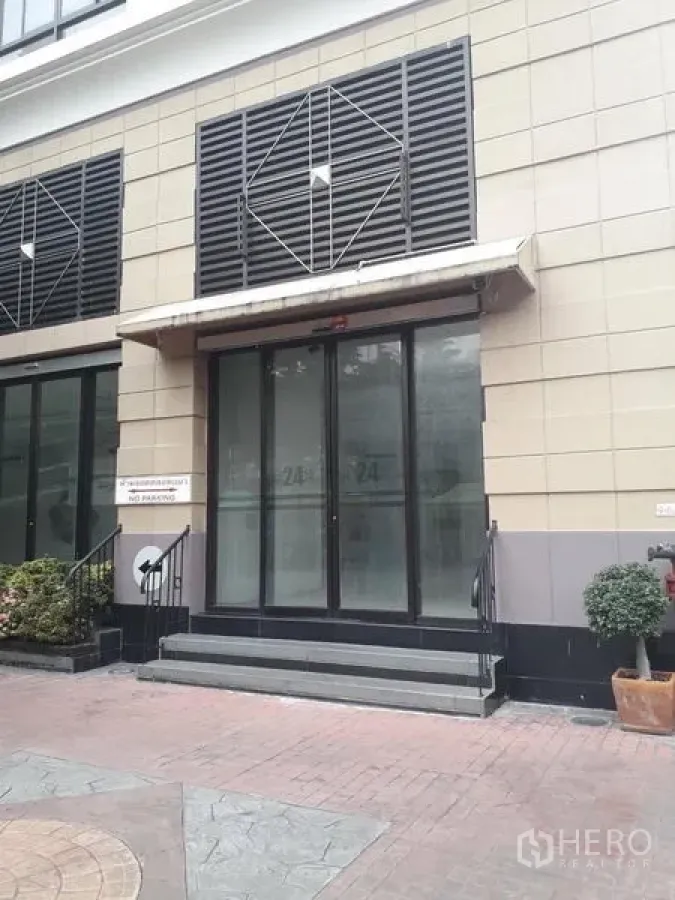 零售空间 出租在Watthana, Bangkok - 临街商铺外立面，玻璃双开门、台阶与雨棚，现代建筑风格。