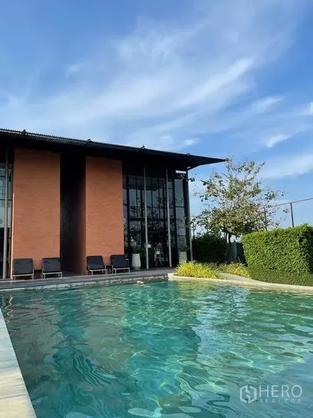 บ้าน ขายในSai Mai, Bangkok - คลับเฮ้าส์สไตล์รีสอร์ตกับเก้าอี้อาบแดดข้างสระว่ายน้ำกลางแจ้งใต้ท้องฟ้าสีฟ้า