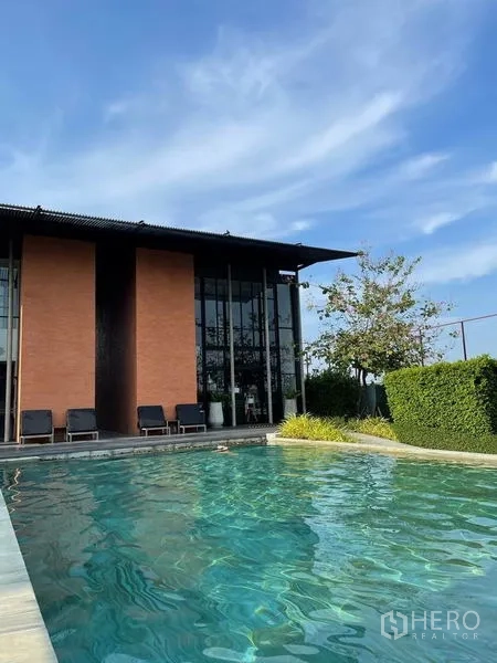 บ้าน ขายในSai Mai, Bangkok - คลับเฮ้าส์สไตล์รีสอร์ตกับเก้าอี้อาบแดดข้างสระว่ายน้ำกลางแจ้งใต้ท้องฟ้าสีฟ้า