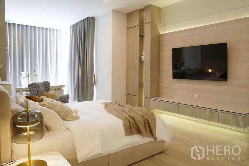 Detached House for rent in Saphan Sung, Bangkok - Master bedroom view toward a TV feature wall with custom storage and soft lighting.