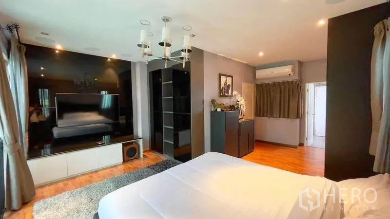 ทาวน์เฮาส์ ให้เช่า - มุมมองห้องนอนมาสเตอร์พร้อมผนังทีวี ตู้เก็บของ และพื้นไม้