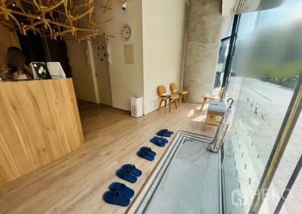 Retail Space for rent - Bright lobby with full-height windows, wood flooring, and seating along the glass frontage.