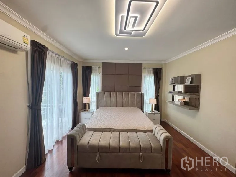 独立式住宅 出租在Prawet, Bangkok - 主卧，宽大床、落地窗帘与现代吸顶灯。