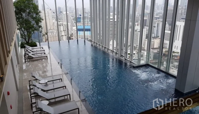 Condominium for rent in Watthana, Bangkok - Rooftop infinity pool with sun loungers and panoramic Bangkok skyline at a high-rise condominium near BTS Nana.