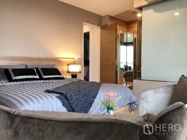 คอนโด ให้เช่าในKhlong Toei, Bangkok - ห้องนอนหลักเตียงคิงส์ไชส์ แสงไฟอบอุ่น พร้อมห้องน้ำในตัวผนังกระจก.