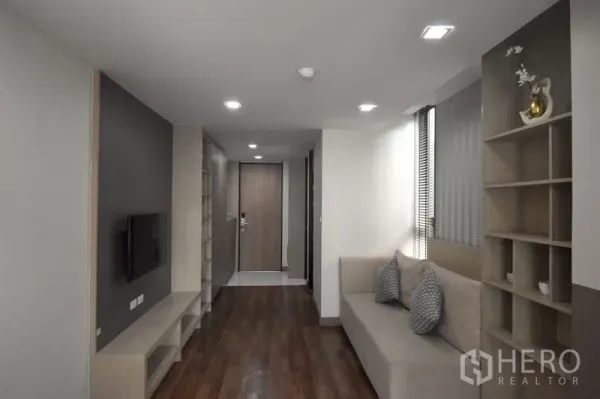 คอนโด ให้เช่าในKhlong Toei, Bangkok - ห้องนั่งเล่นพร้อมโซฟา ผนังติดทีวี พื้นไม้ และชั้นโชว์แบบบิวท์อิน