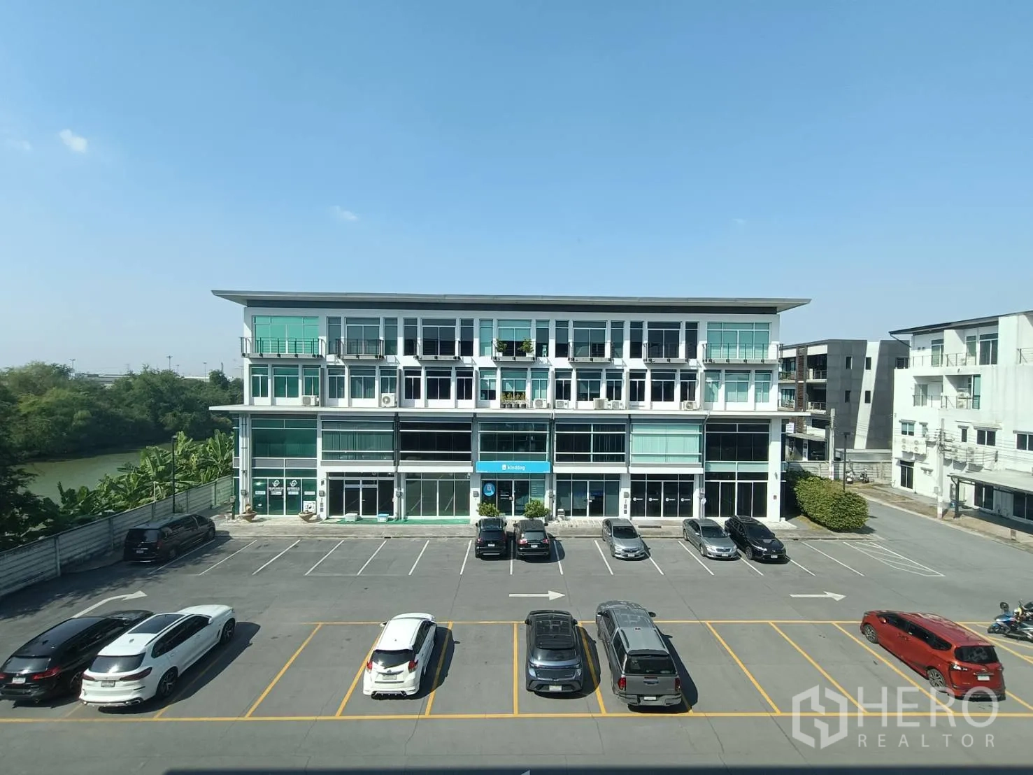 带办公室的家 for rent or sale in Prawet, Bangkok - 室内眺望对面三层商业楼与停车场的景观。
