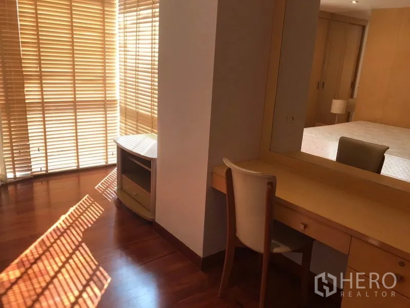 คอนโด ให้เช่าในWatthana, Bangkok - มุมห้องนอนหลักพร้อมโต๊ะเครื่องแป้ง เก้าอี้ และแสงแดดลอดผ่านมู่ลี่ไม้