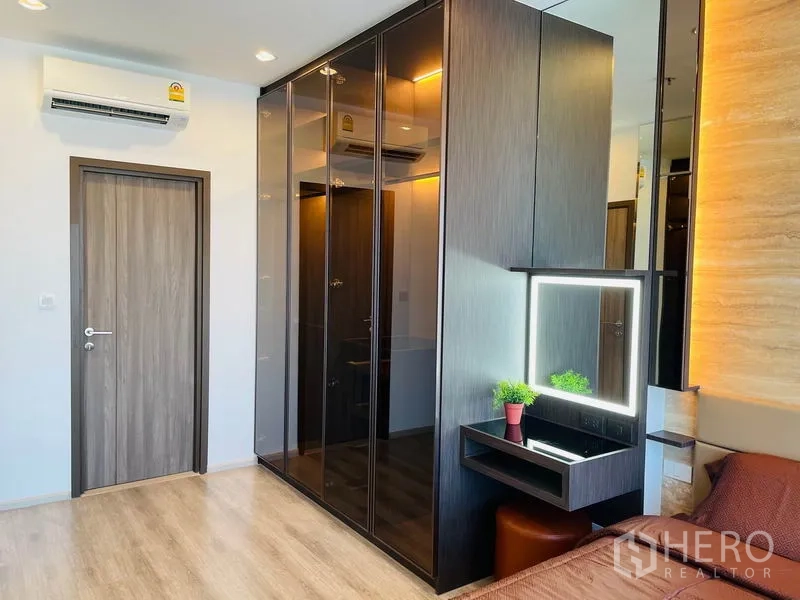 คอนโด ให้เช่าในBang Na, Bangkok - ห้องนอนมาสเตอร์พร้อมตู้เสื้อผ้าบิวท์อินบานเงาและโต๊ะเครื่องแป้งไฟส่อง