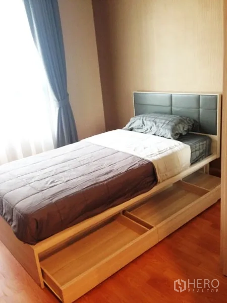 Condominium for rent or sale in Mueang Samut Prakan, Samut Prakan - Second bedroom featuring storage bed with drawers, padded headboard and bright window.