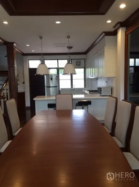 独立式住宅 出租在Khlong Toei, Bangkok - 餐厅面向带中岛的厨房和不锈钢冰箱，顶置筒灯。