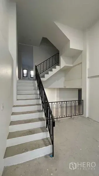 联排别墅 出售在Prawet, Bangkok - 黑色金属栏杆的楼梯连接多层空间。