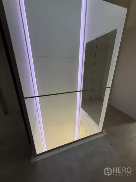 Shophouse for rent - View of the private home elevator shaft with soft LED lighting and glass enclosure.