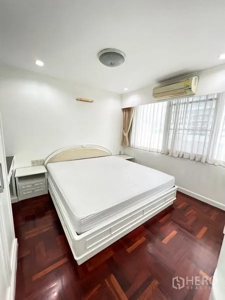 คอนโด ให้เช่าในWatthana, Bangkok - ห้องนอนมุมห้องมีหน้าต่างบานใหญ่ เตียงควีน แอร์ และพื้นไม้