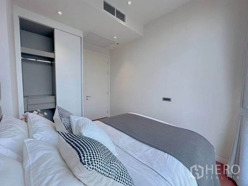 公寓 出租在Watthana, Bangkok - 极简次卧，内置衣柜与中性色床品。