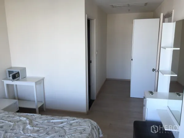 公寓 出租或出售在Khlong Toei, Bangkok - 卧室一角设梳妆台、置物架、衣柜与通往卫浴的门。